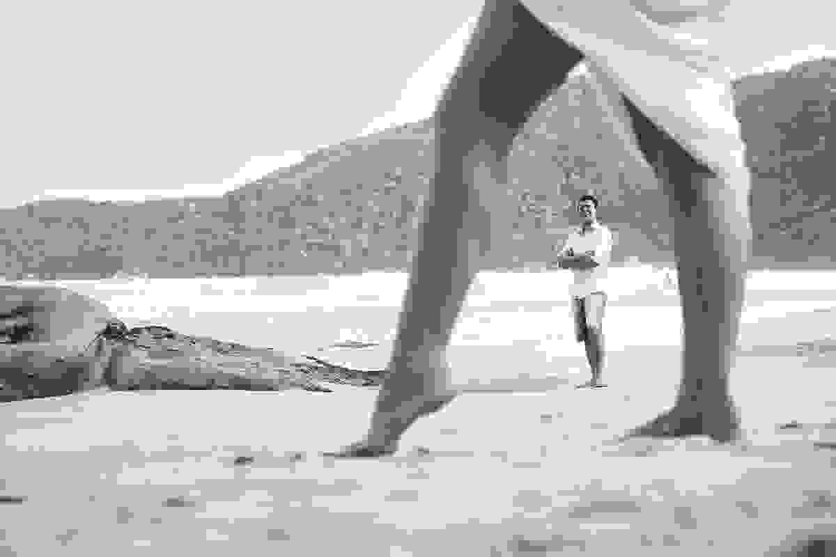 pernas da noiva e noivo ao fundo em praia no rj