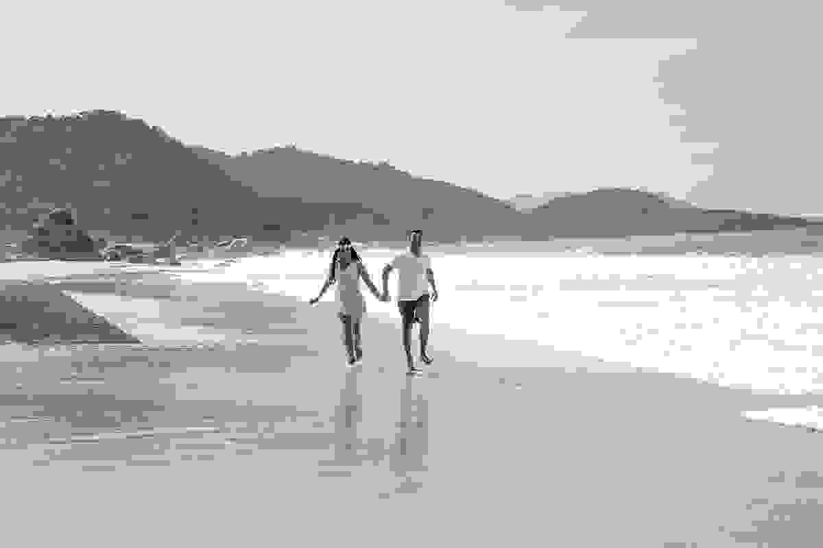 casal correndo na praia fotografia preto e branco