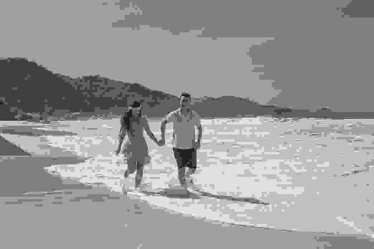noivos correndo a beira da praia