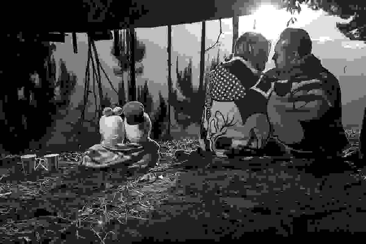 casal de noivos sentados com cobertor e por do sol