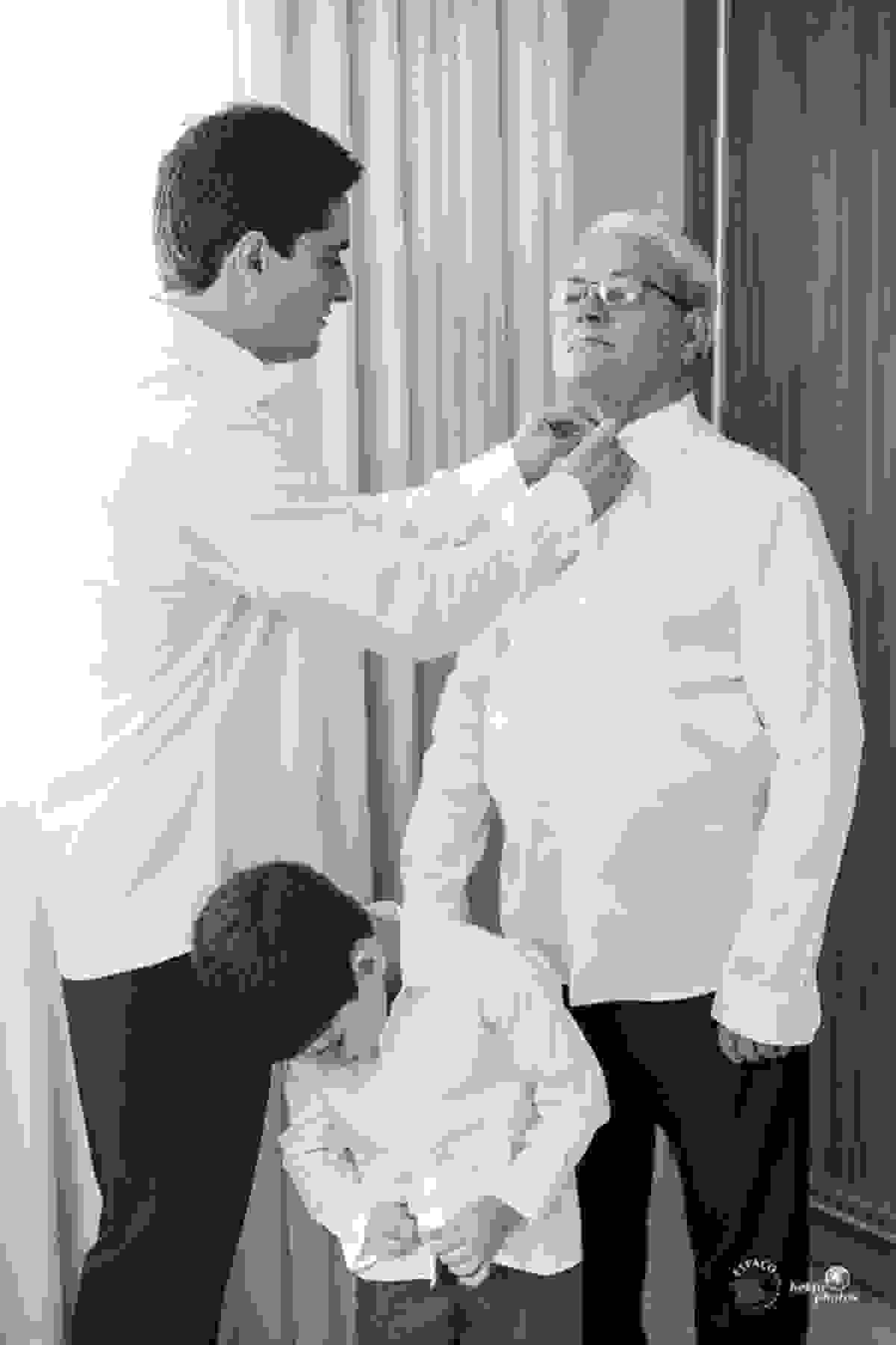 Noivo arrumando o pai para a cerimonia de casamento