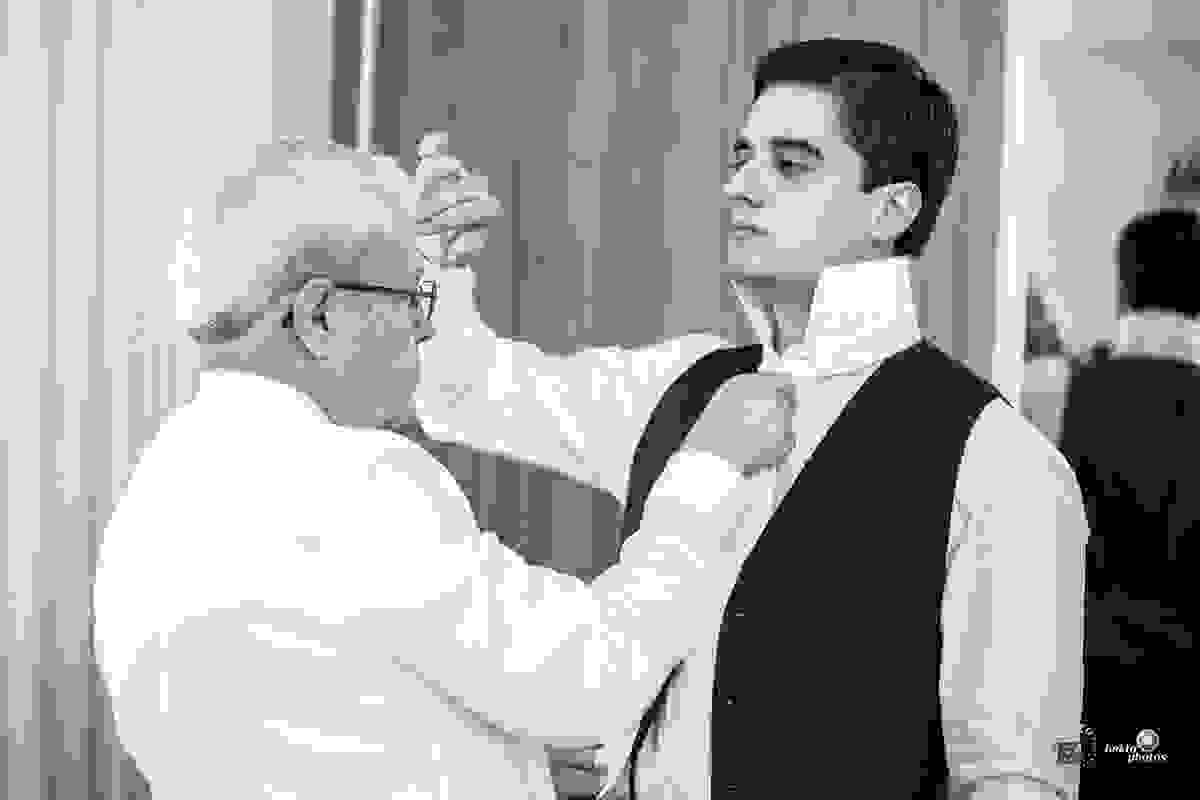 Pai arrumando o noivo para a cerimonia de casamento que aconteceu na Catedral de Goiânia
