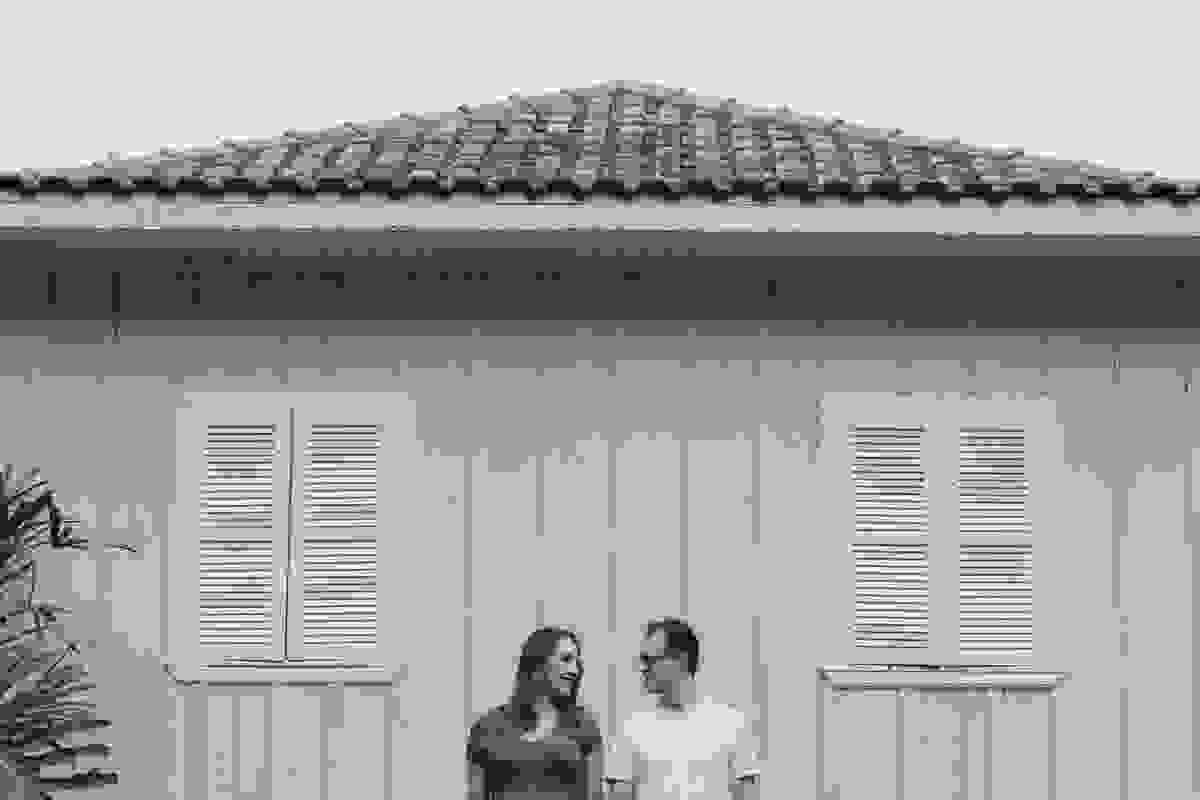 Casal se olhando em frente a parede amarela, entre duas janelas