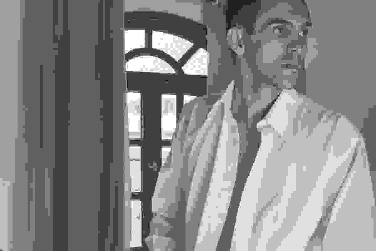 noivo aolhando para o lado enguanto começa a vestir a camisa para o casamento em cabo frio