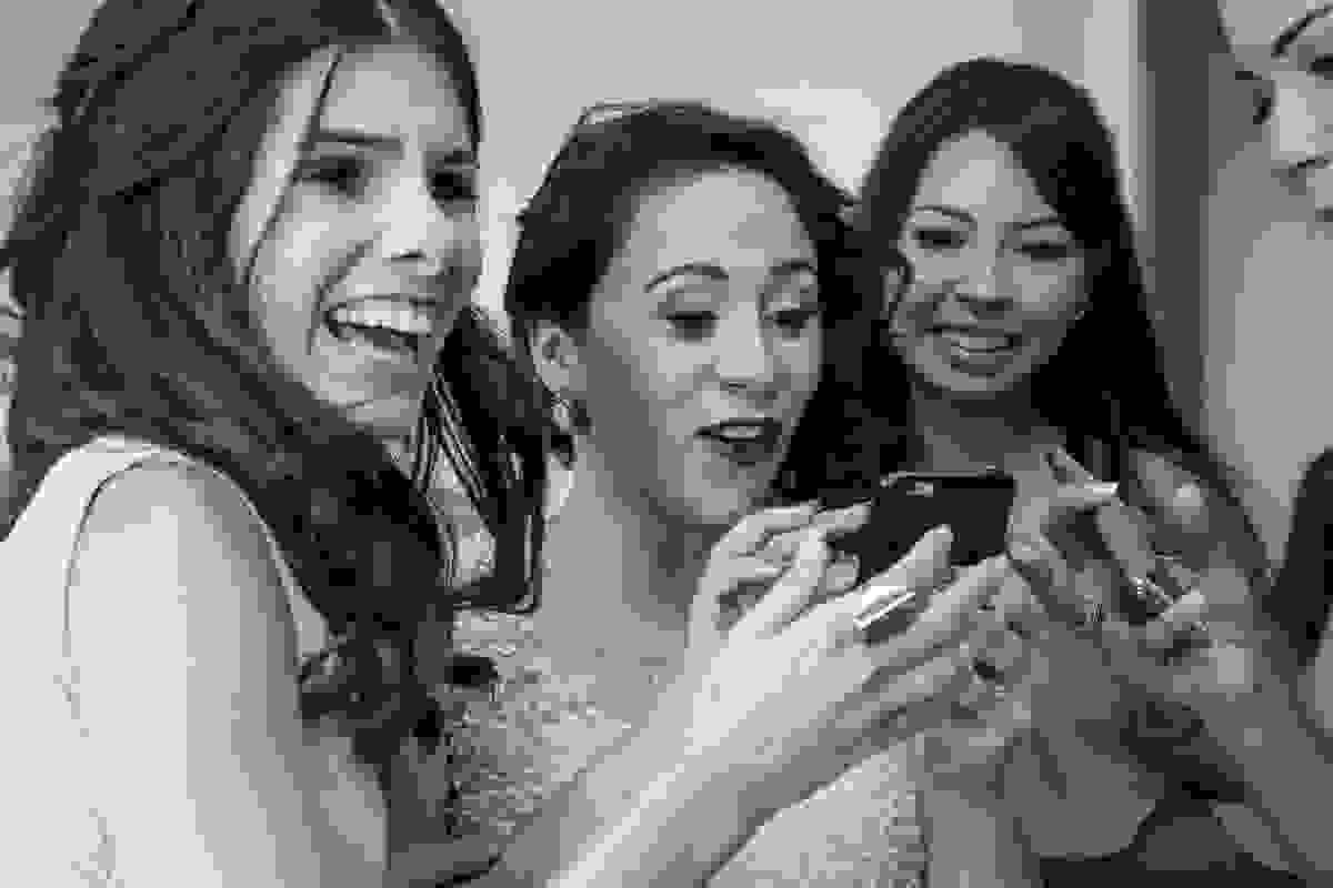 madrinhas se divertem olhando selve feita no making off da noiva no casamento em cabo frio