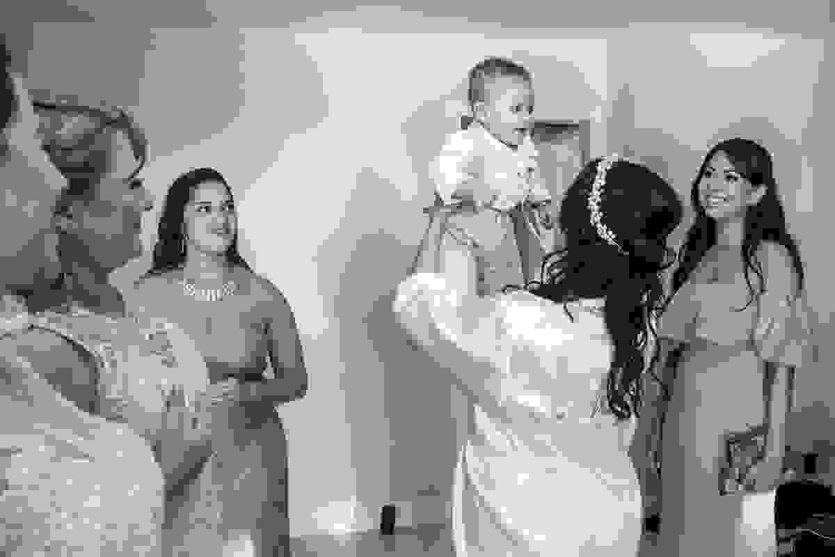 fotorgafo registra noiva segurando um bebê sorrindo no casamento em cabo frio