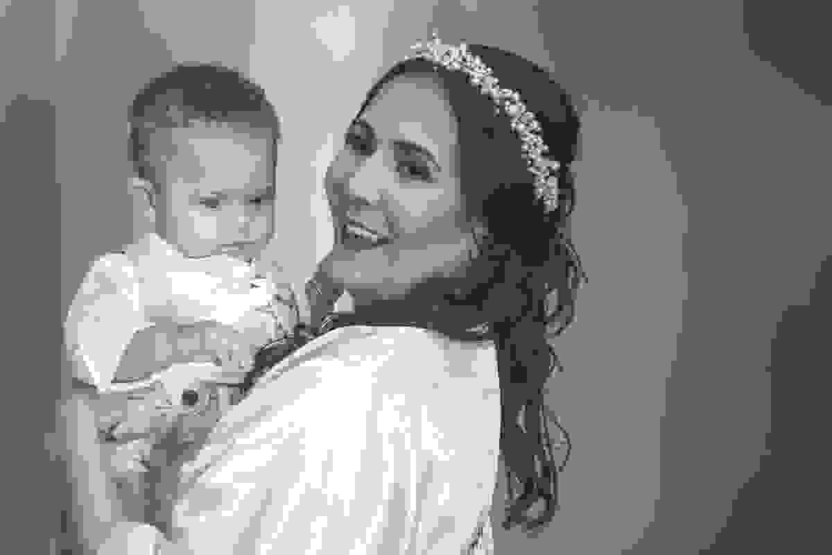 noiva sorri enguanto segura bebe em fotorgafia de casamento em Cabo Frio Rio de Janeiro