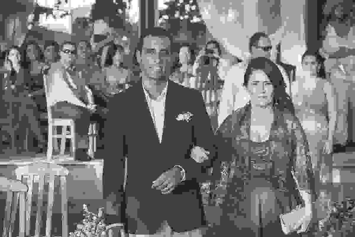 Pai do noivo e mãe da noiva entrando no cortejo de braços dados em fotografia de casamento em cabo frio rio de janeiro