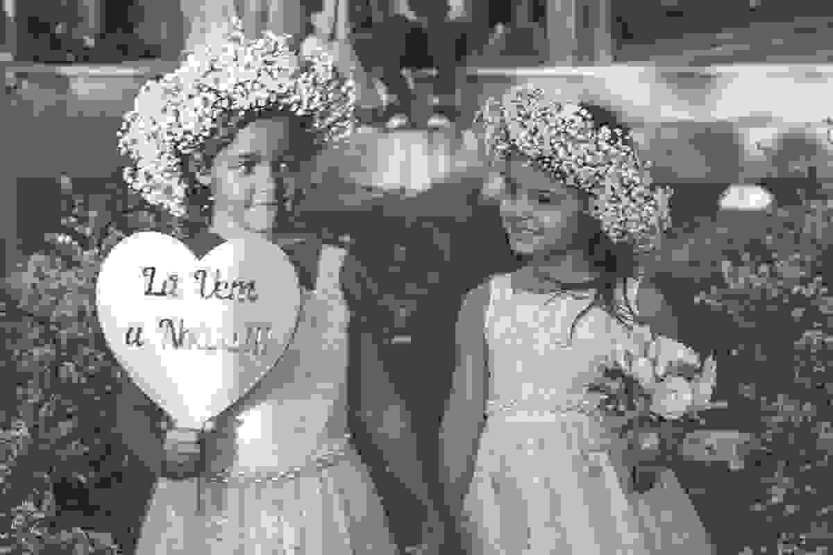 daminhas entrando em cortejo com placa de la vem a noiva em fotografia de casamento em cabo frio rio de janeiro