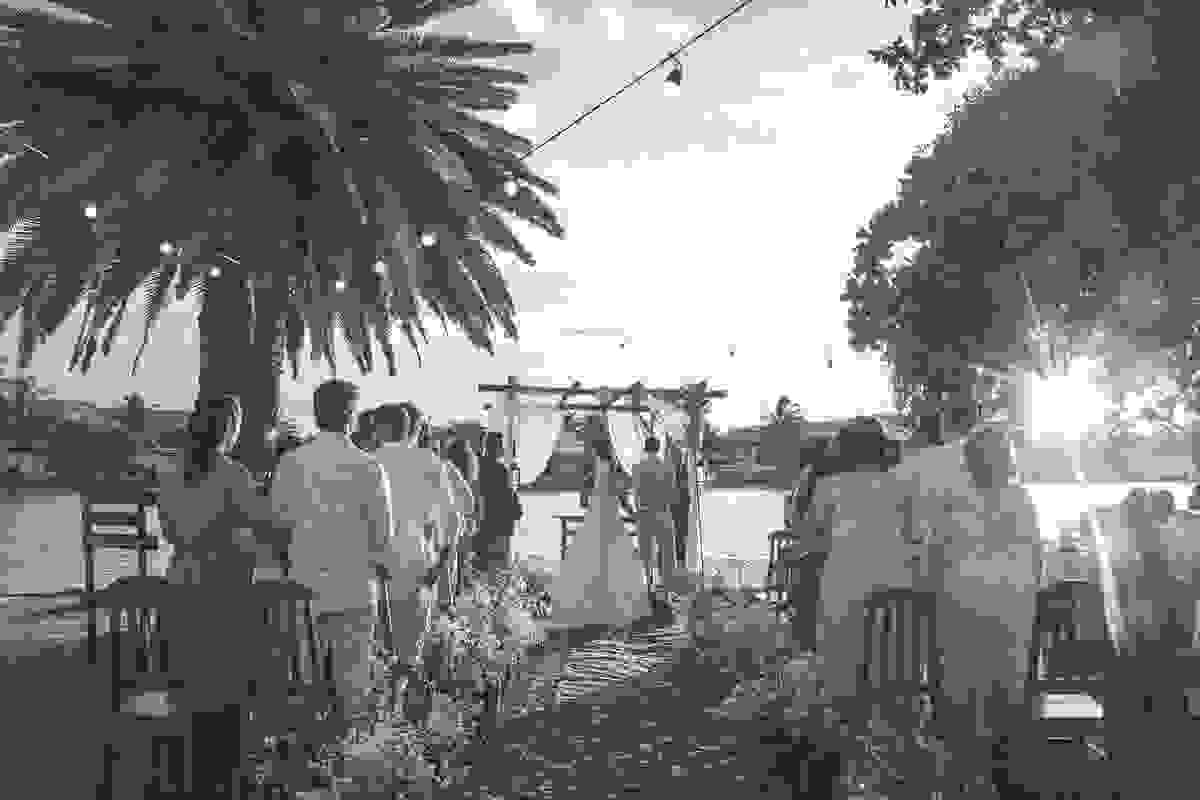 Foto de taz mostrando o casal recebendo as benções do padre e ao fundo o ceu e o canal de Cabo Frio Rio de Janeiro