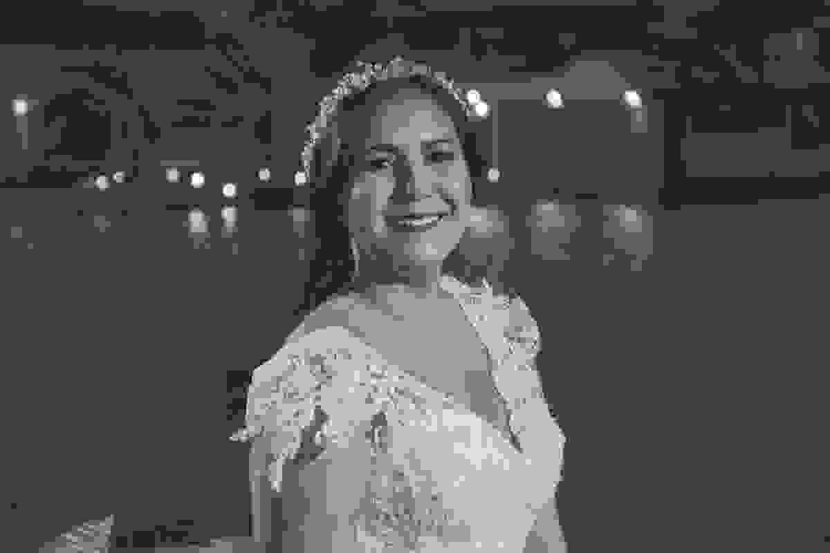 Fotografia mostra noiva sorrindo em casamento enguanto posa para foto com o canal de cabo frio ao fundo