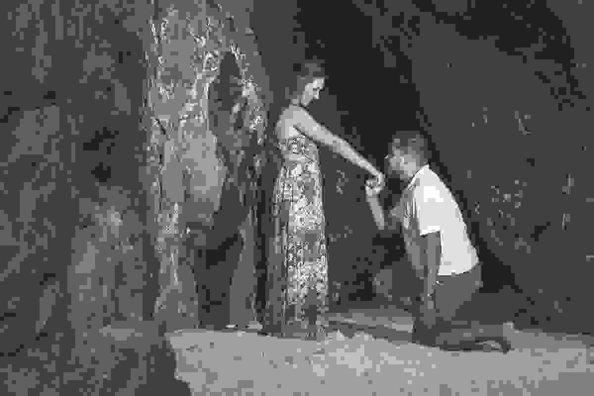 Noivo se ajoelha e beija a mão da noiva em fotografia de pedido de casamento em ensaio fotográfico em arraial do cabo rio de janeiro