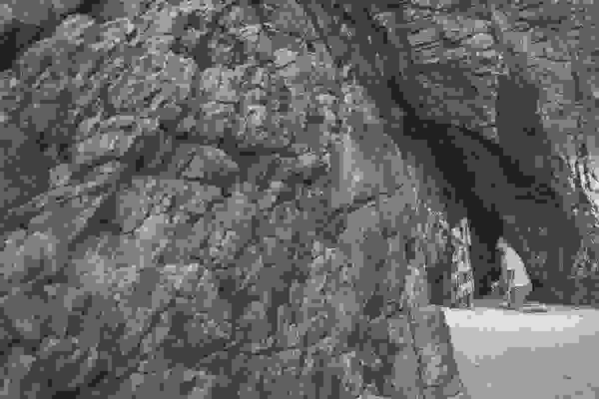 Ensaio fotográfico pré casamento mostra foto da entrada da gruta do amor em arraial do cabo onde o casal aparece bem no cantinho a noiva com o rosto tapado e o noivo ajoelhado