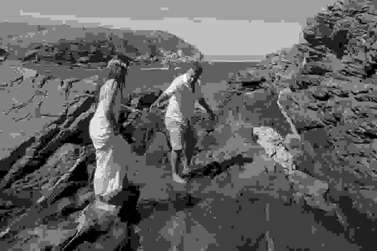 noivo ajuda a noiva a passar pelas pedras e pequena lagoa formada pelo acumu-lo de agua do mar de cabo frio em ensaio pré casamento