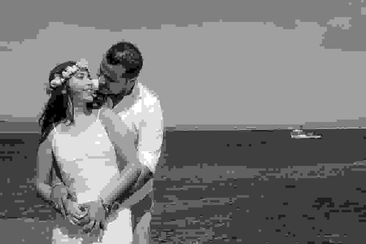 casal abraçado com o mar de fundo ela olhando para ele em fotografia de pre casamento em cabo frio rio de janeiro