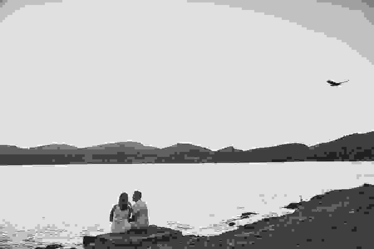 casal sentado de frente para o canal de cabo frio fotografia em preto e branco