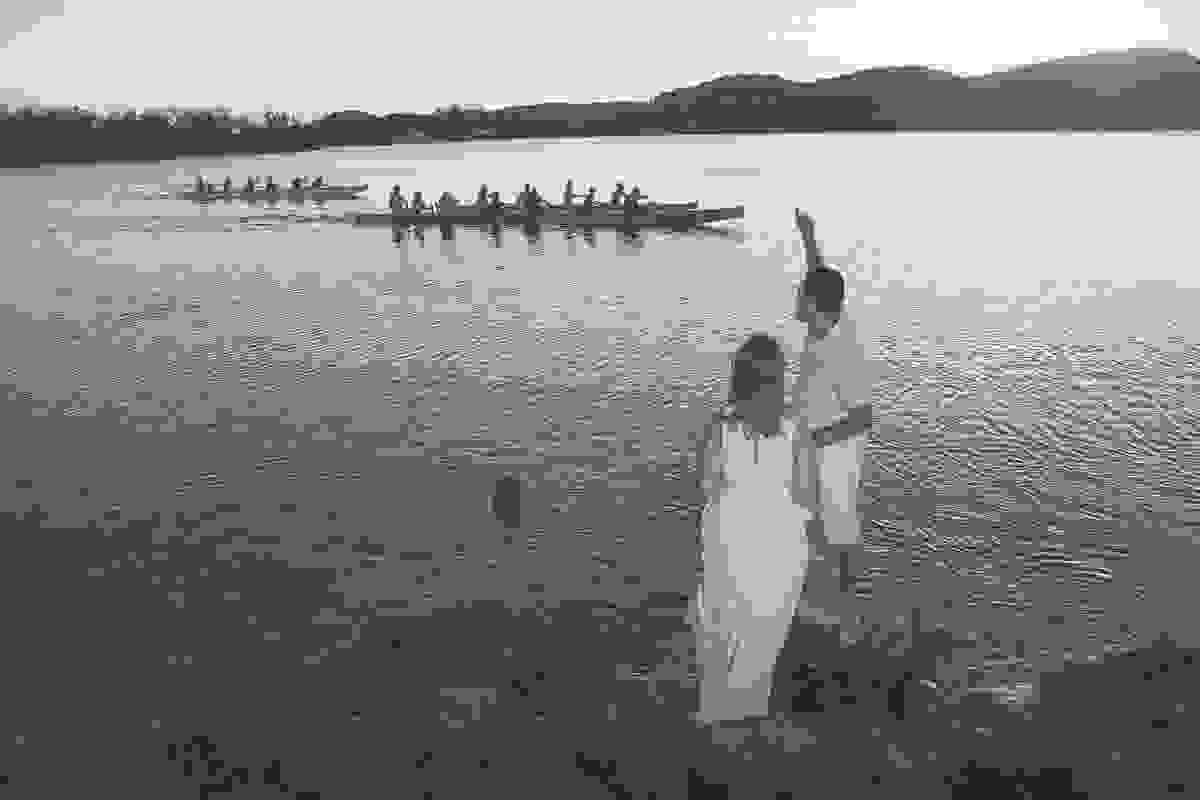 Casal de noivos acenando para barco a remo
