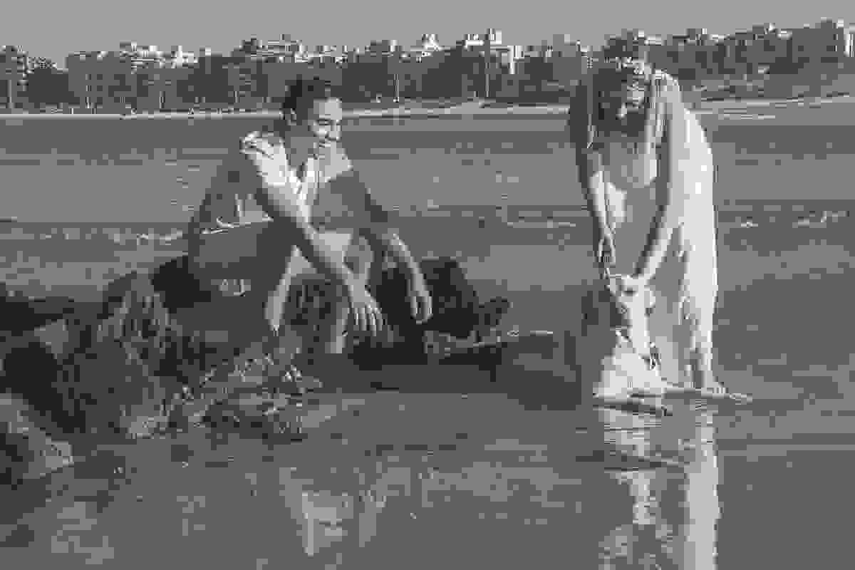 Casal brincando com o cachorro na beira do mar de cabo frio ensaio pré casamento