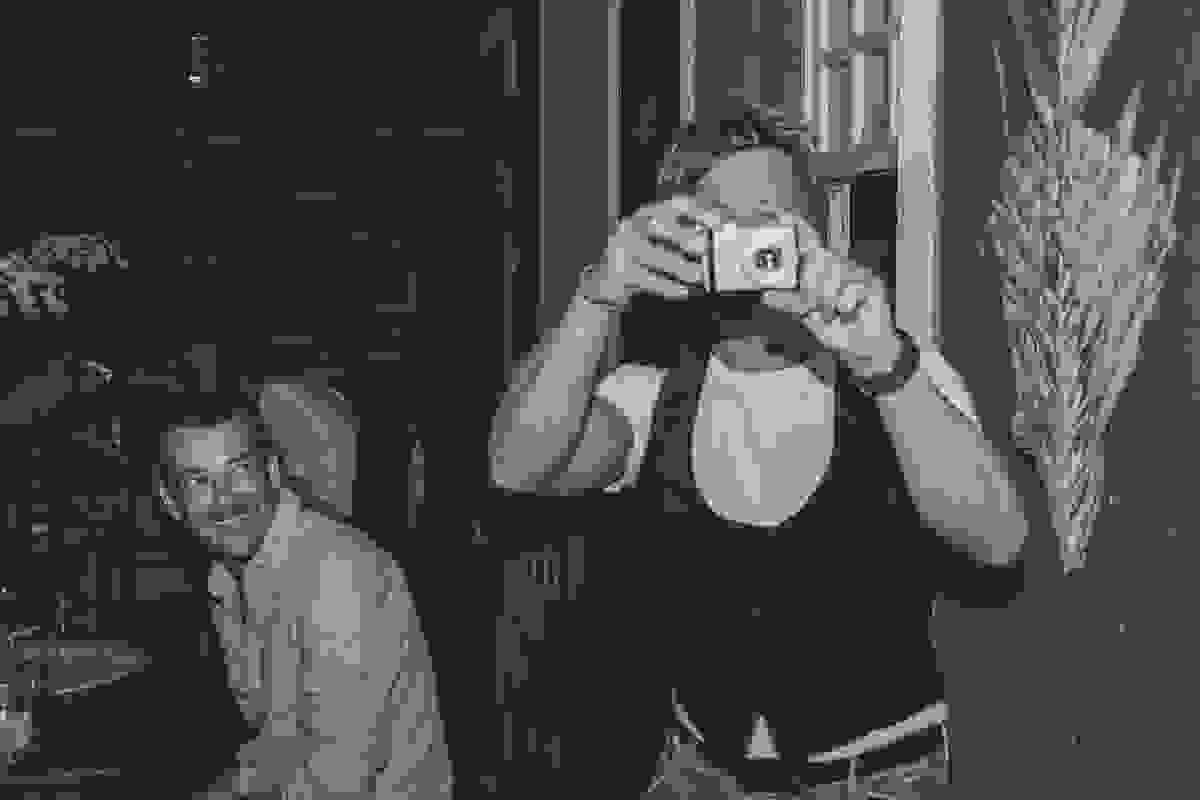 Convidado tira uma foto do fotografo do casamento ao mesmo tempo que é fotografado com a camera na mão