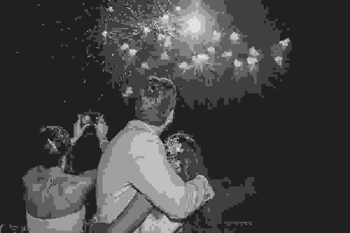 casal observa os fogos do casamento estourarem no ceu em um belo espetáculo