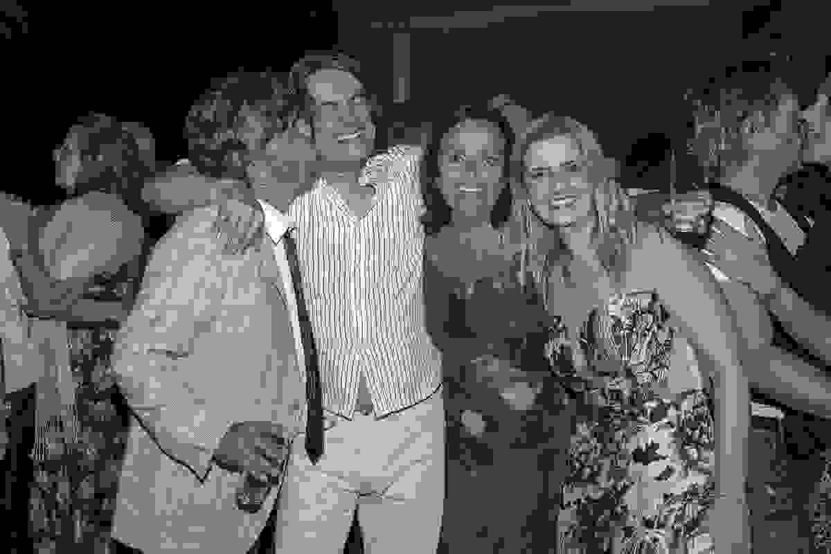 fotografia com o pai e mãe da noiva e o cantor da banda e sua esposa. Na foto o fotografo registra o momento que o pai da noiva dá um beijo no rosto do cantor