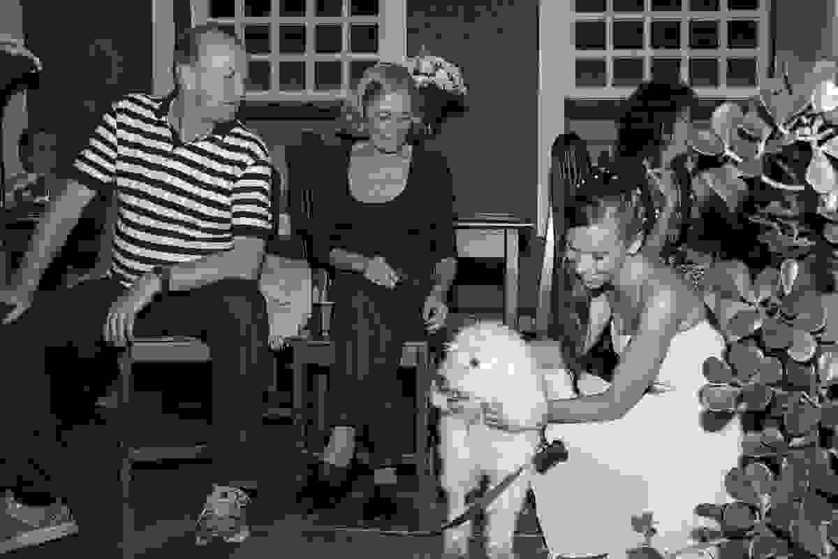 convidados levam para a festa do casamento um lindo cachorrinho. Fotografia mostra uma as convidadas mimando o animal