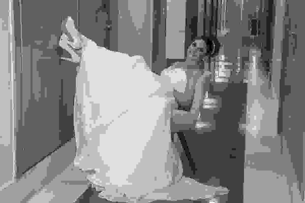noiva sentada em cadeira com os pes para o alto sorrindo para fotografia do casamento