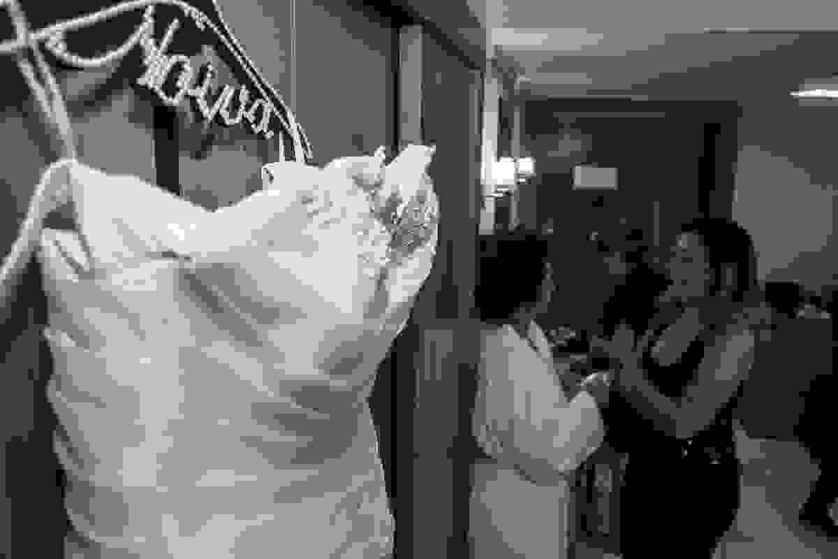 noiva conversando e em um canto a foto mostra o vestido da noiva pendurado