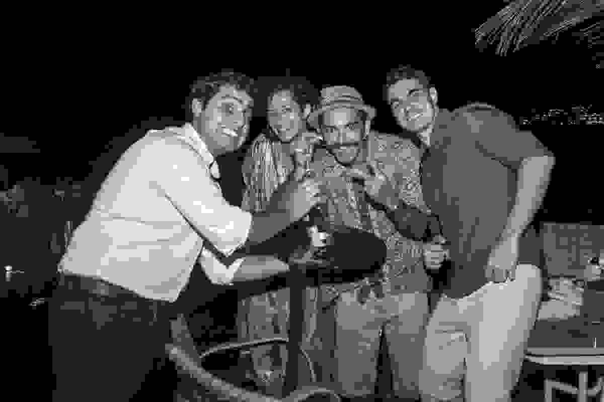 Amigos passando o corte da gravata do noivo