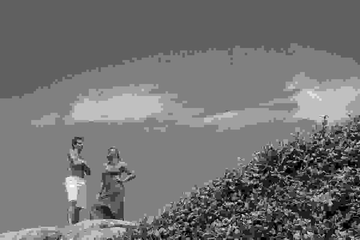 Casal posando no alto da pedra da praianha em ensaio pré casamento na praia