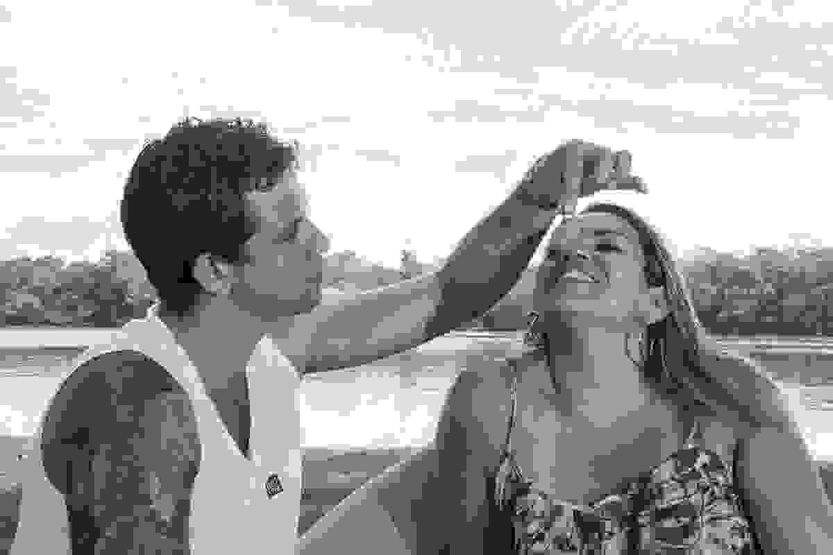 Noivo dá uva na boca da noiva em ensaio romantico a beira do rio são joão