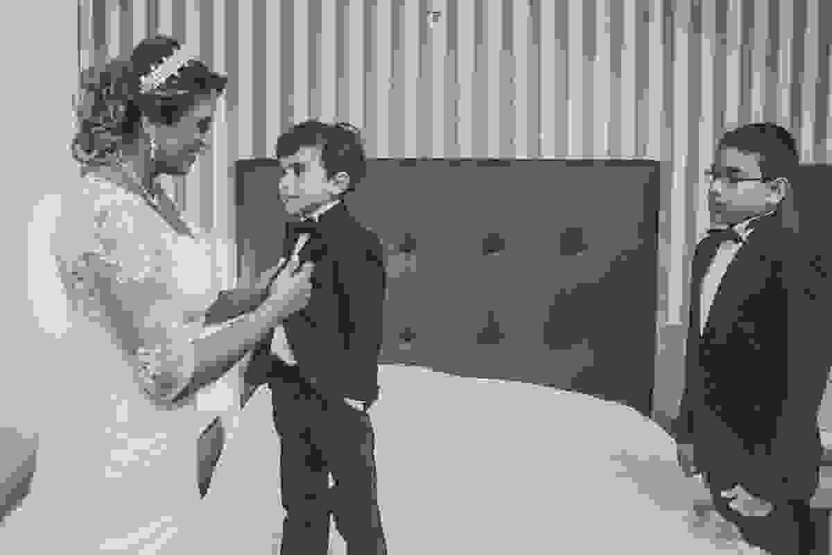 noiva ajudando o filho mais novo a se arrumar para o casamento