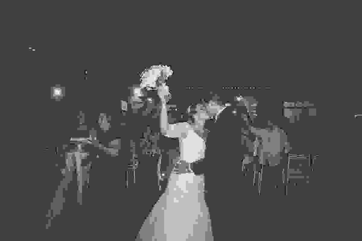 casal se beija e noiva erque o bouquet casamento