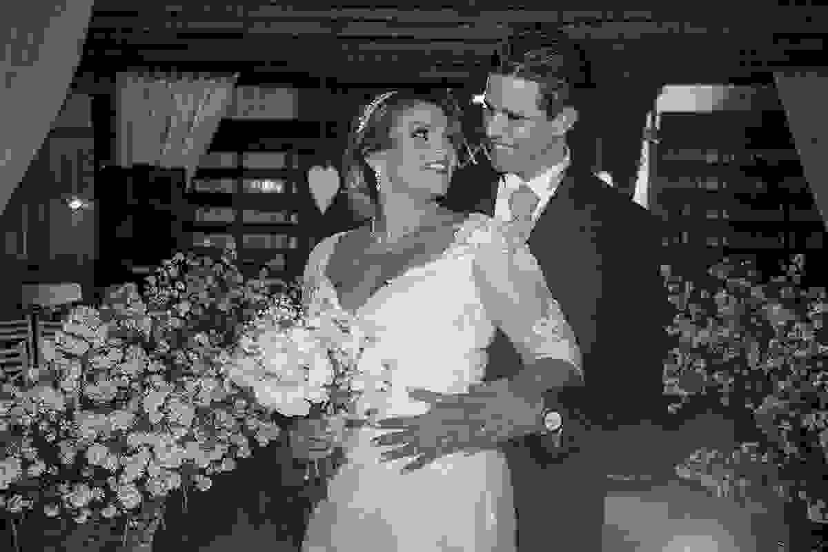 noivo sorri enguanto abraça a noiva em pose do casamento