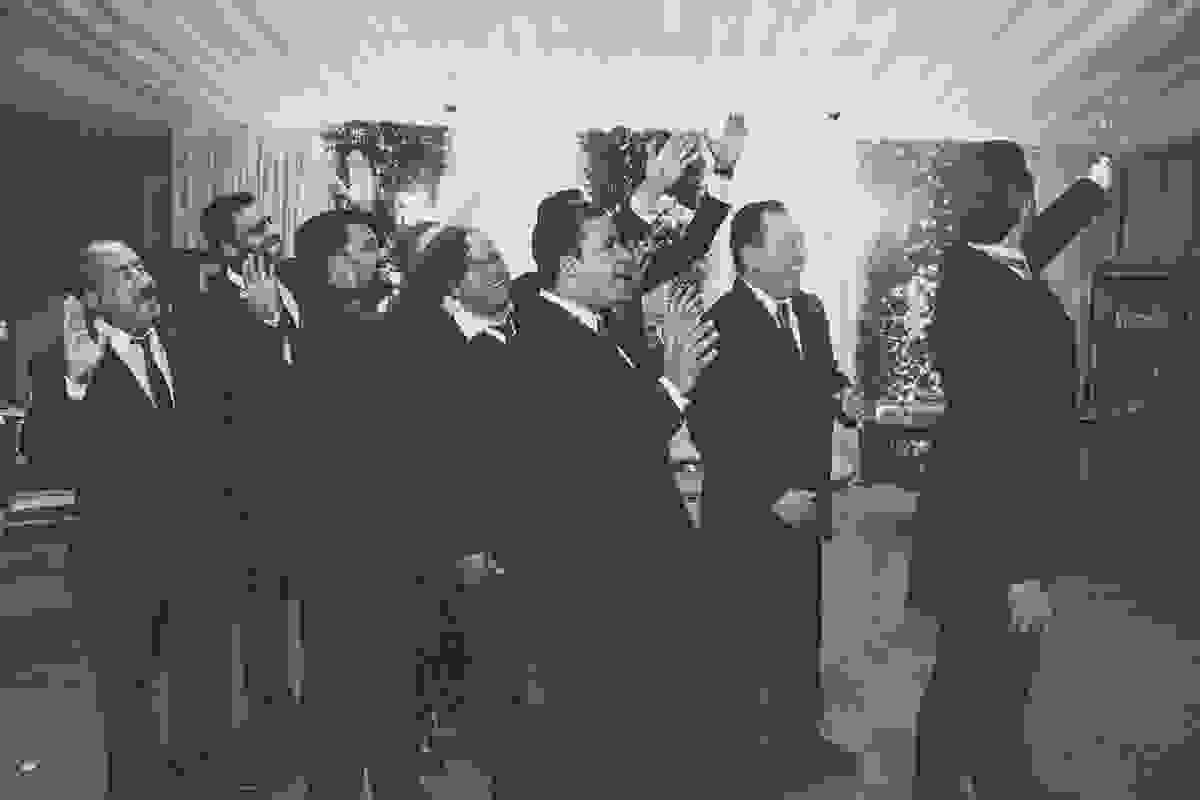 noivo fazendo brincadeira com a aliança junto com seus padrinhos durante fotos do casamento