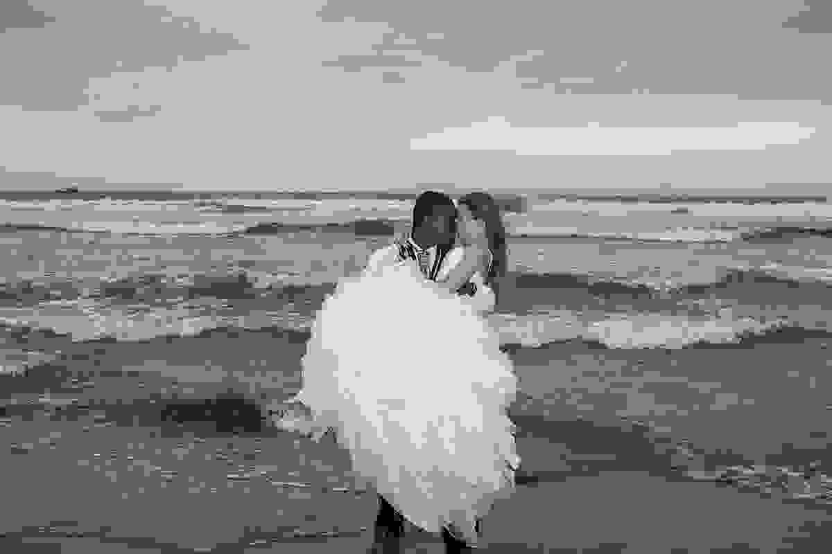Noivo pega noiva no colo em fotografia preto e branco do ensaio pós casamento