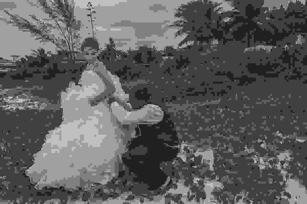 Noivo ajuda a arrumar vestido da noiva em ensaio pós casamento praia de geribar em búzios