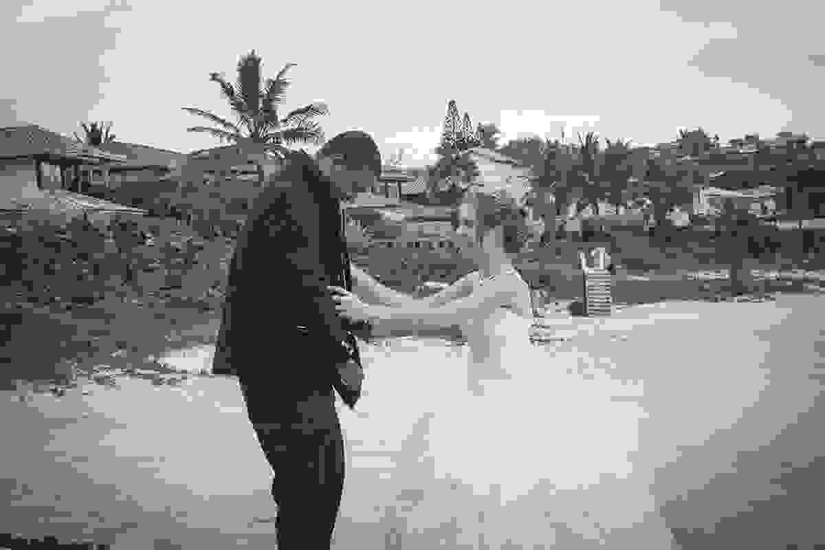 Noiva ajuda o noivo a colocar o paletó para o Trash The Dress