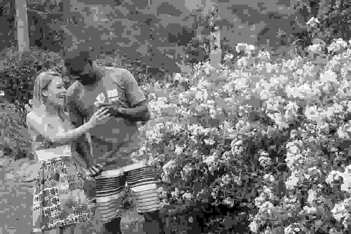 Ensaio pré casamento em Rio das Ostras noivo oferece flor para noiva que sorri feliz