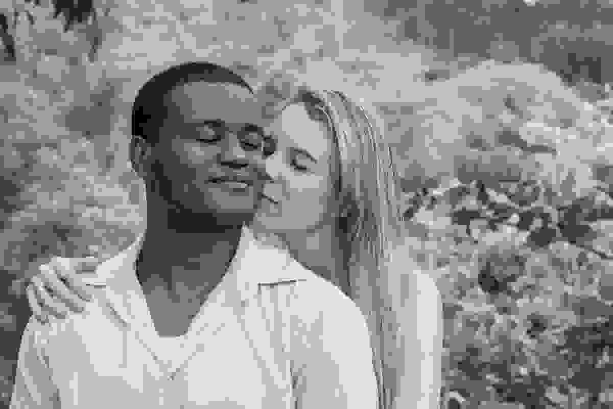casal em sintonia ela dando um cheiro no pescoço do noivo em ensaio pré casamento rio das ostras