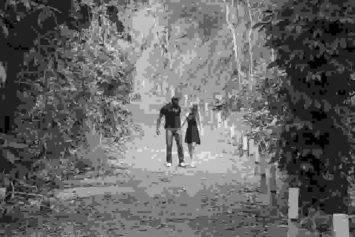 casal caminhando de mãos dadas no parque da cidade de rio das ostras RJ