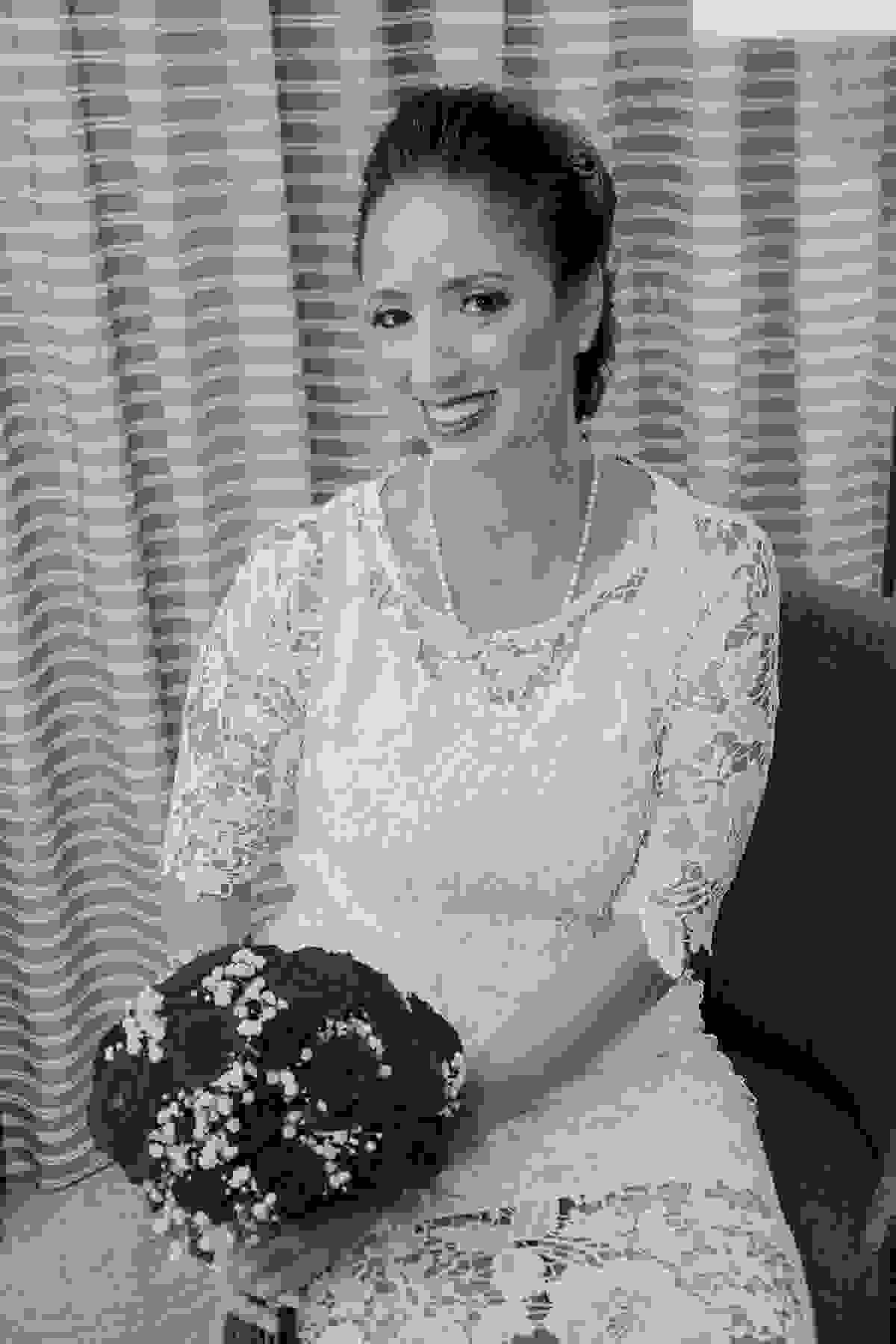 Noiva sentada segurando o bouquet posa para fotografia de casamento em seu making off no rio de janeiro