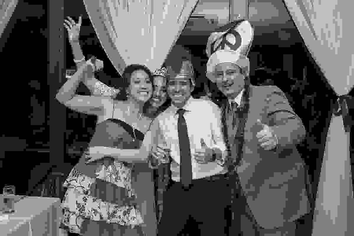 Noivo se divertindo com amigos com chapeus coloridos durante o casamento