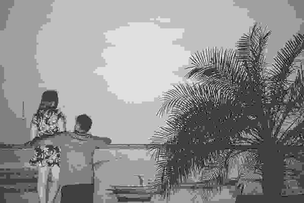 Casal esta debruçado em mureta de vidro no final da galeria olhando o mar a sua frente em ensaio fotográfico em Armação dos Búzios Rio de Janeiro