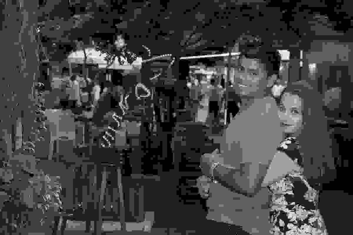 Casal abraçado ela abrando ele por traz e ao fundo as luzes do comercio da Rua das Pedras em Búzios Rio de Janeiro