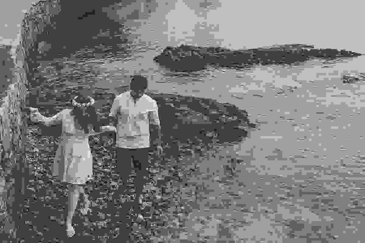 casal caminha por entre as pedras em fotografia monocromática feita em ensaio fotográfico em búzios rio de janeiro