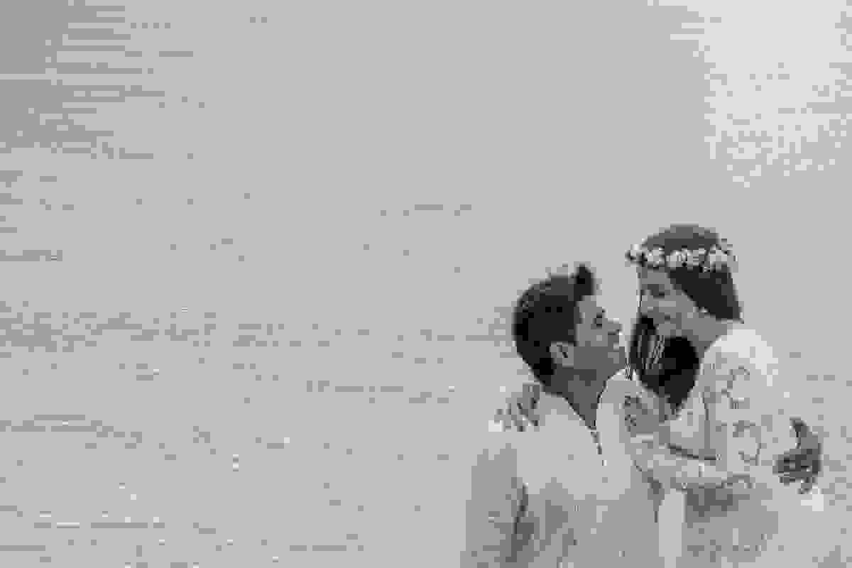 fotografia de casal de olhando sorrindo e ao fundo a praia da armação de búzios rio de janeiro que foi cenário para o ensaio pós casamento
