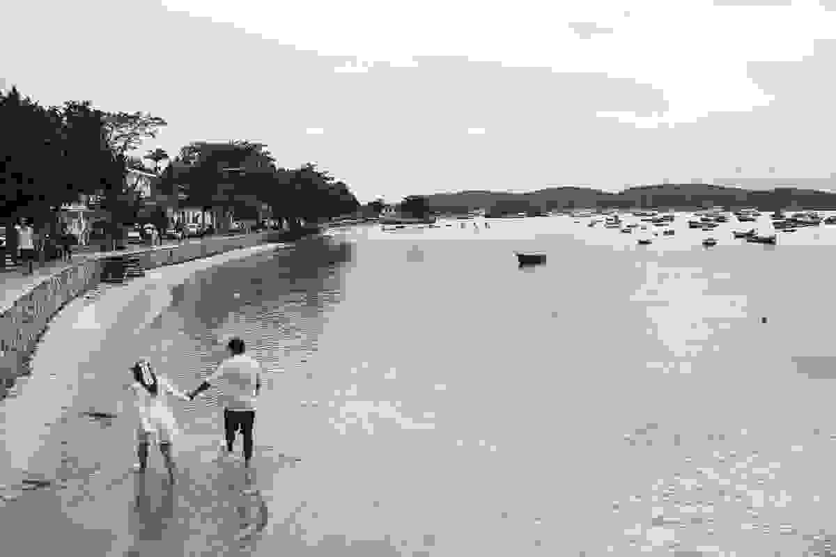 ensaio pós casamento fotografado por Paulo Ellias em armação dos búzios rio de janeiro mostra casal caminhando pela beira da praia