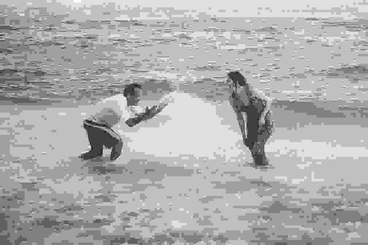 Foto casal brincando na água do mar do atalaia em Arraial do Cabo no Rio de Janeiro