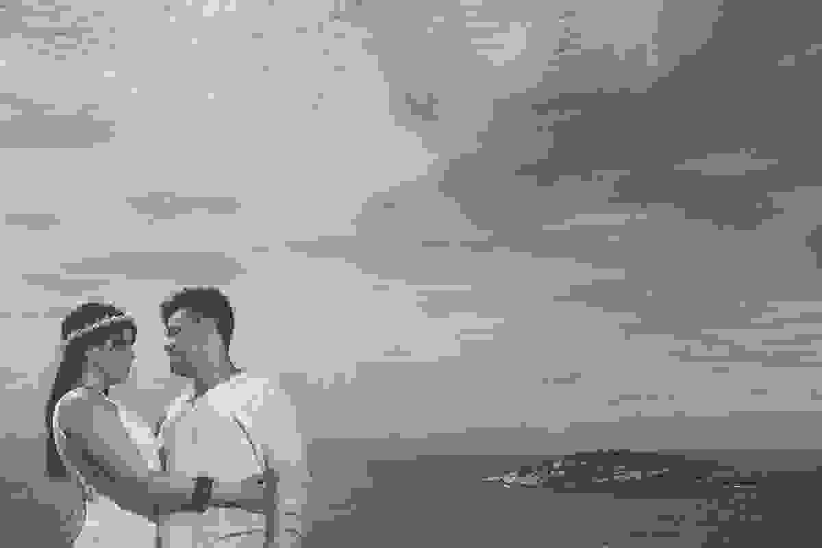 Fotografia pré casamento em joão fernandes búzios o click do fotorgafo mostra o casal de noivos em pé olhando um para o outro e ao fundo o ceu e o mar de búzios